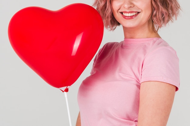 Vrouw het stellen met ballon voor valentijnskaarten