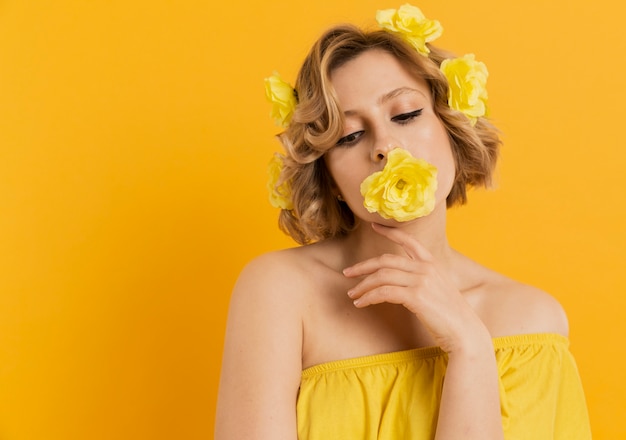 Vrouw het stellen met bloem die haar mond behandelt