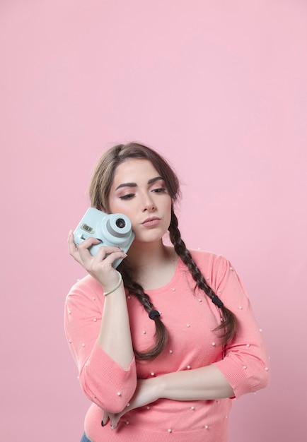 Vrouw het stellen met camera naast gezicht en exemplaarruimte