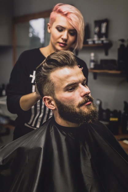 Vrouw het stileren klant in salon