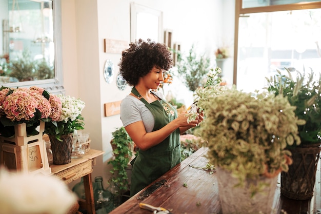 Vrouw het verzorgen van bloemen in bloemenwinkel