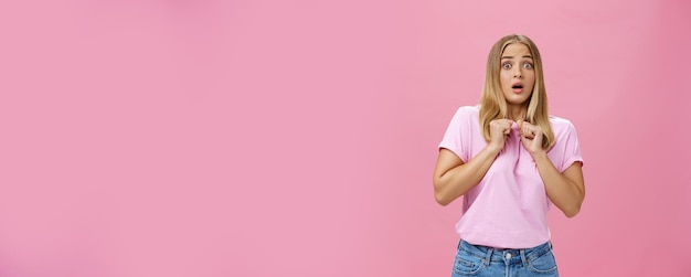 Gratis foto vrouw hijgend van angst, bang gemaakt door iemand die gebalde handen tegen de borst drukt terwijl ze naar achteren buigt