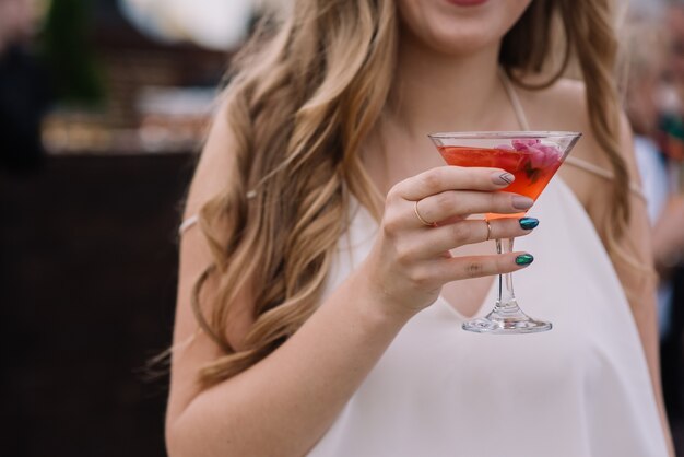 Vrouw houdt cocktailglas in haar hand