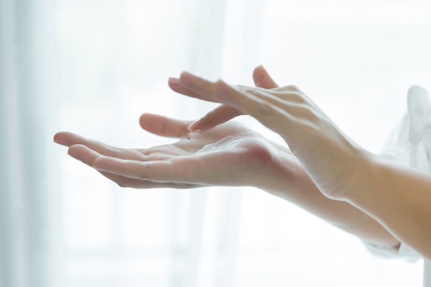 vrouw houdt een pot met een cosmetische crème in haar handen