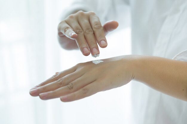 vrouw houdt een pot met een cosmetische crème in haar handen