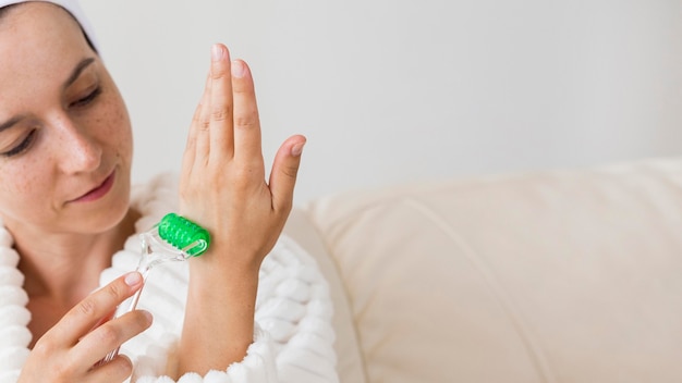 Vrouw in badjas met behulp van een massage-instrument