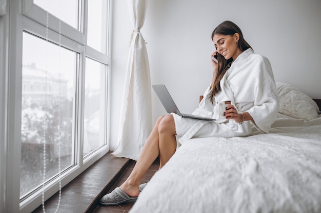 Vrouw in badjas zittend in bed