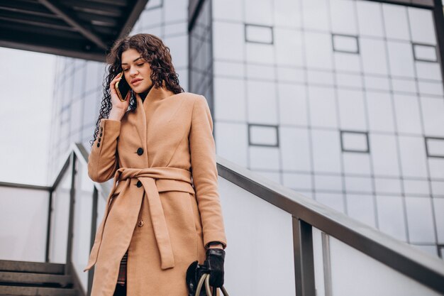 Vrouw in beige jas wandelen in de stad