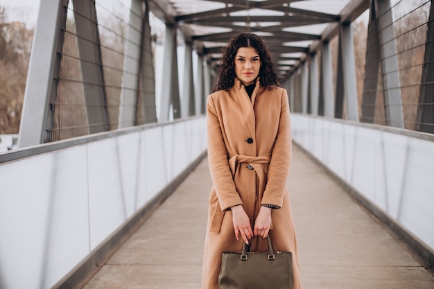 Vrouw in beige jas wandelen in de stad