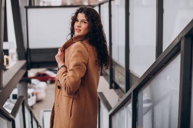 Vrouw in beige jas wandelen in de stad