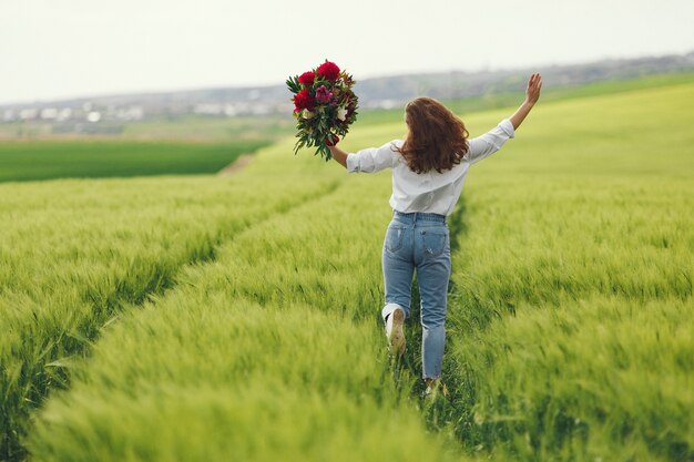 Vrouw in blauw shirt in een zomer veld