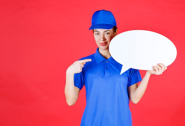 Gratis foto vrouw in blauw uniform met een ovale ideebord.