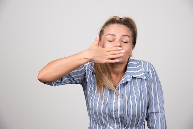 Gratis foto vrouw in blauwe trui die zich slaperig voelt.