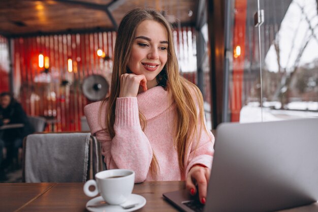 Vrouw in café koffie drinken en werken op een computer