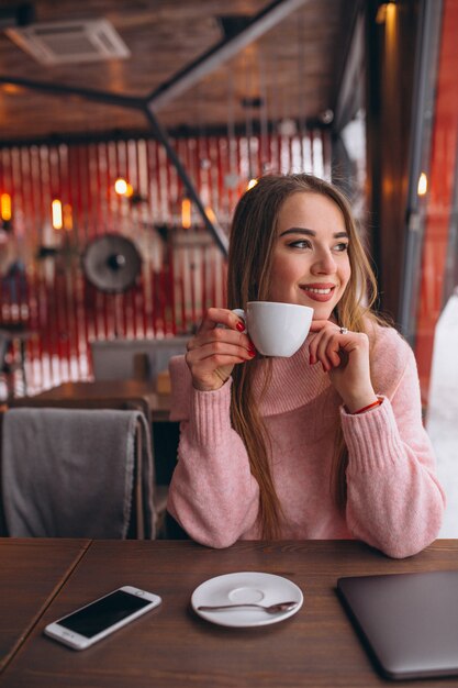 Vrouw in café koffie drinken en werken op een computer