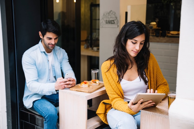 Gratis foto vrouw in cafetaria die aan tablet werkt