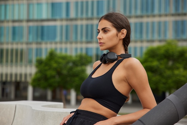 vrouw in cropped top denkt na over het organiseren van lessen voor verschillende niveaus van fitness en vaardigheden bezit sportclub denkt over lifestyle-kwesties geniet van recreatieve activiteiten