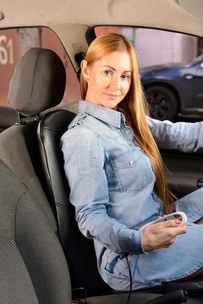 Vrouw in de auto met massage kussen