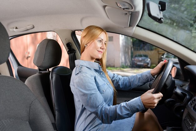 Vrouw in de auto met massage kussen