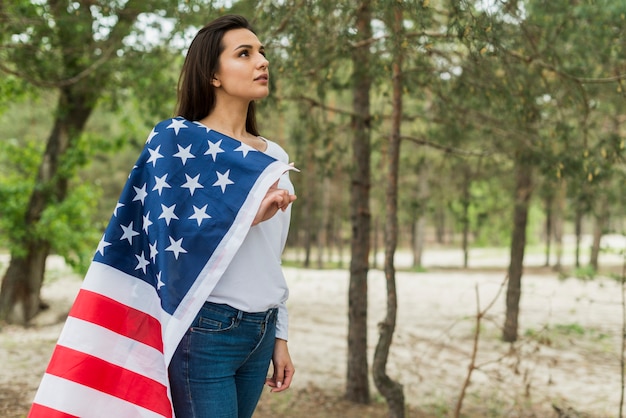 Vrouw in de natuur met Amerikaanse vlag
