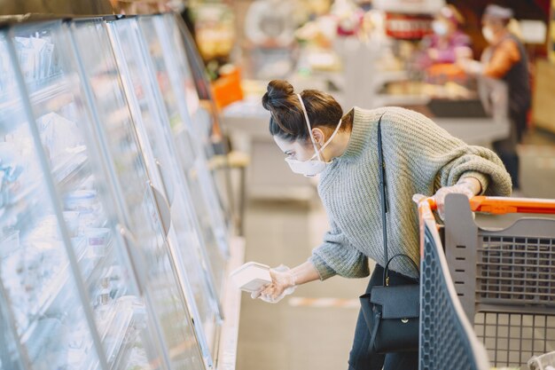 Vrouw in een beschermend masker in een supermarkt