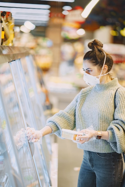 Vrouw in een beschermend masker in een supermarkt