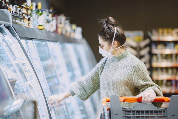 Vrouw in een beschermend masker in een supermarkt