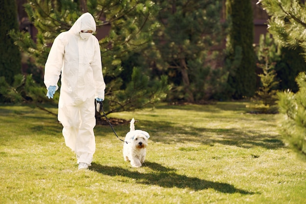 Vrouw in een beschermend pak wandelen met een hond