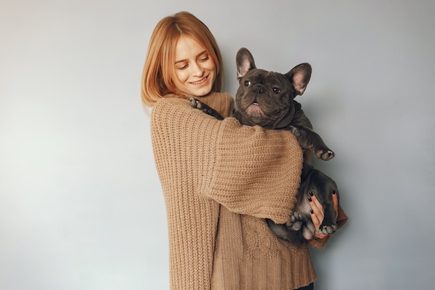 vrouw in een bruine trui met zwarte bulldog