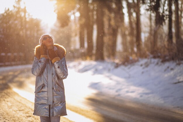 Vrouw in een de winterpark die op de telefoon spreken