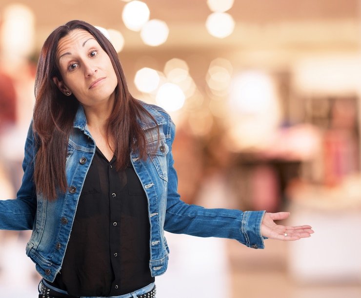 Gratis Foto vrouw in een denim jasje met schouders en opgeheven palmen