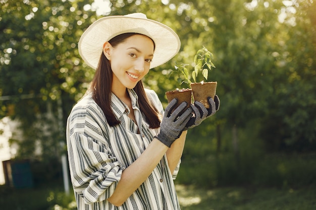 Vrouw in een hoed met bloempotten