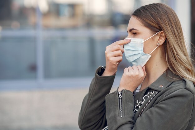 Vrouw in een masker staat op straat