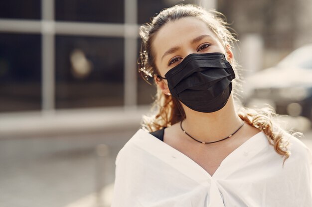 Vrouw in een masker staat op straat