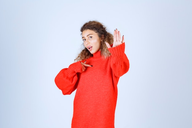 vrouw in een rood shirt die iets stopt en voorkomt.