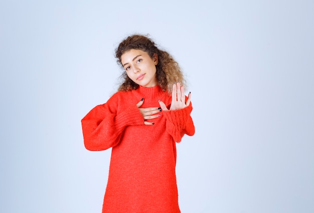 vrouw in een rood shirt die iets stopt en voorkomt.