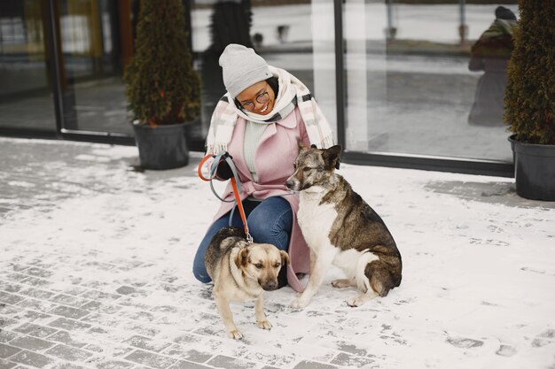 Vrouw in een roze jas met honden