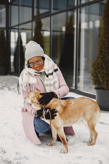 Gratis foto vrouw in een roze jas, wandelende hond