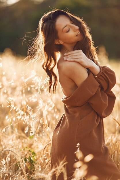 Vrouw in een zomer-veld. Brunette in een bruine trui.