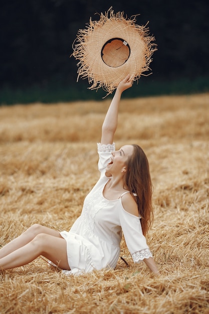 Vrouw in een zomer-veld. Dame in een witte jurk.