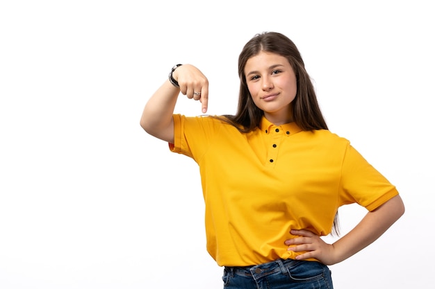 vrouw in geel shirt en blauwe spijkerbroek poseren met gelukkige uitdrukking op de witte achtergrond vrouw model kleding