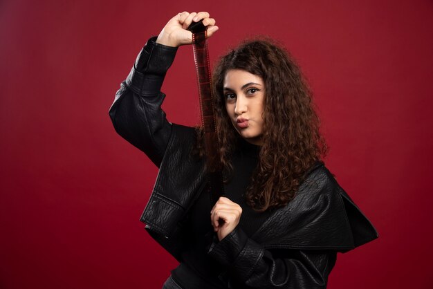 Vrouw in geheel zwarte outfit met een fotoband.