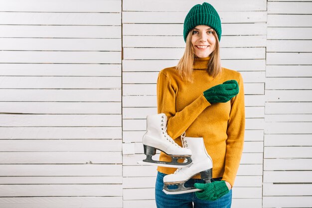 Vrouw in gele trui met schaatsen