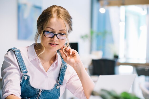 Vrouw in glazen die in bureau werken