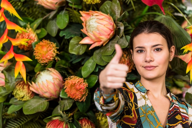 Vrouw in groen huis die duim tonen