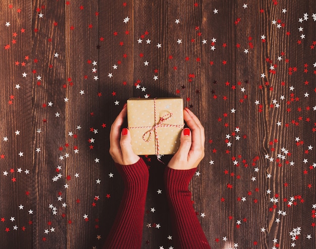 Gratis foto vrouw in hand met kerst geschenk doos