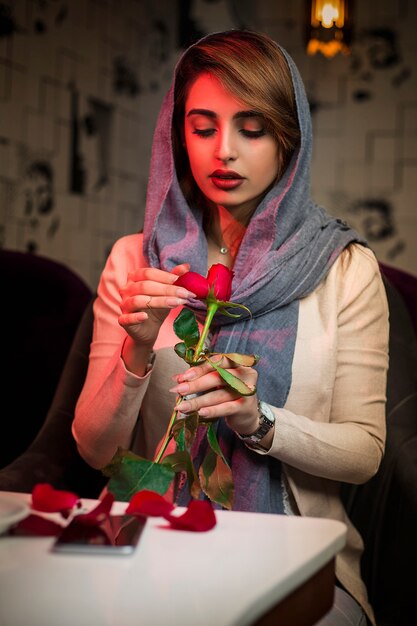 Vrouw in hijab met een roos in restaurant