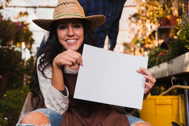 Gratis foto vrouw in hoed met papieren blad