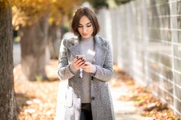 Vrouw in jas met telefoon