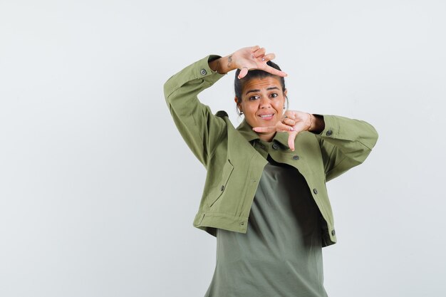 Vrouw in jasje, t-shirt frame gebaar maken en op zoek dartel